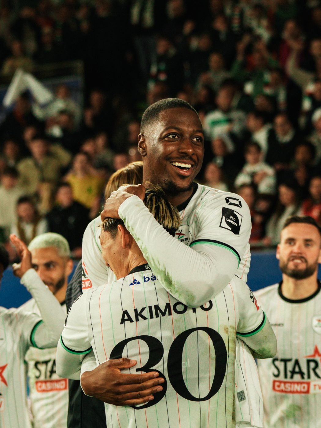 two players embrace, smiling after the final whistle