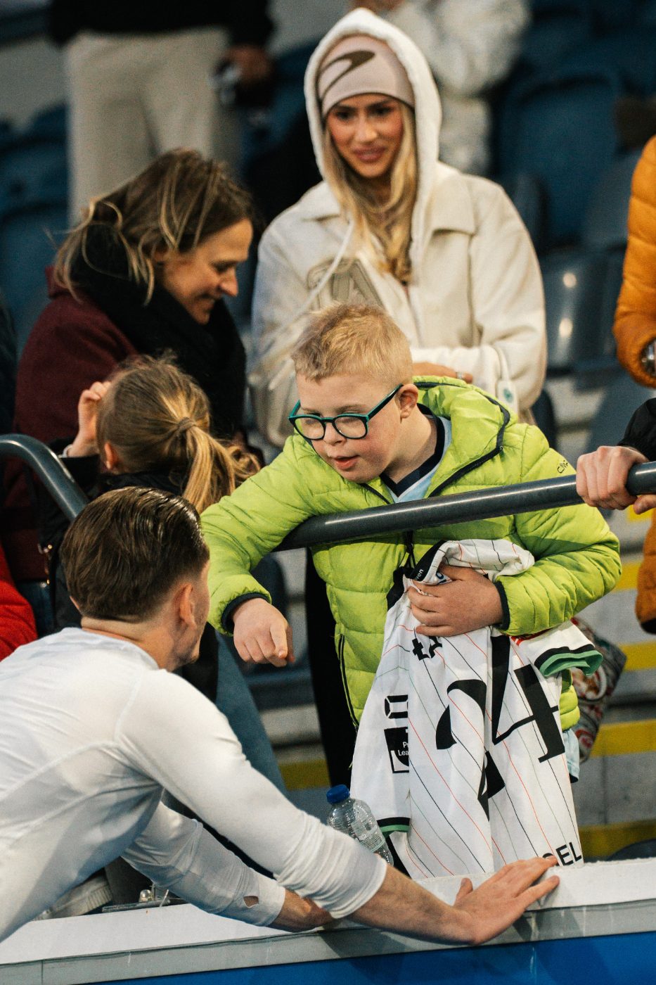 a young supporter reaches over the barrier